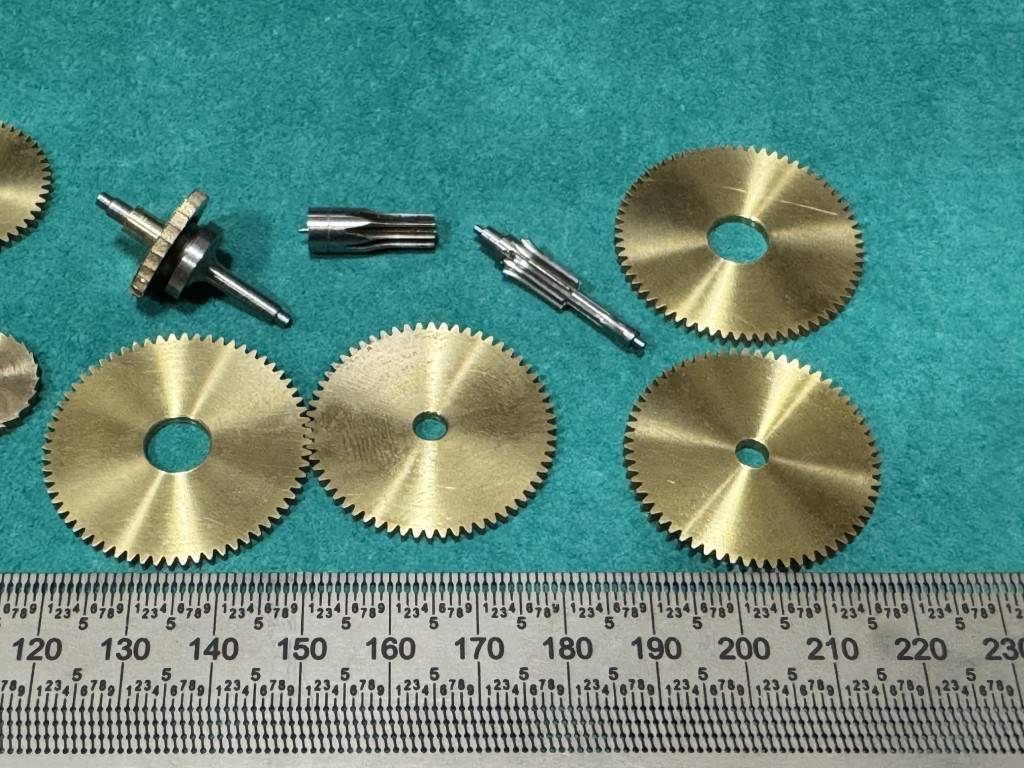 Brass gears and pinions beside a ruler