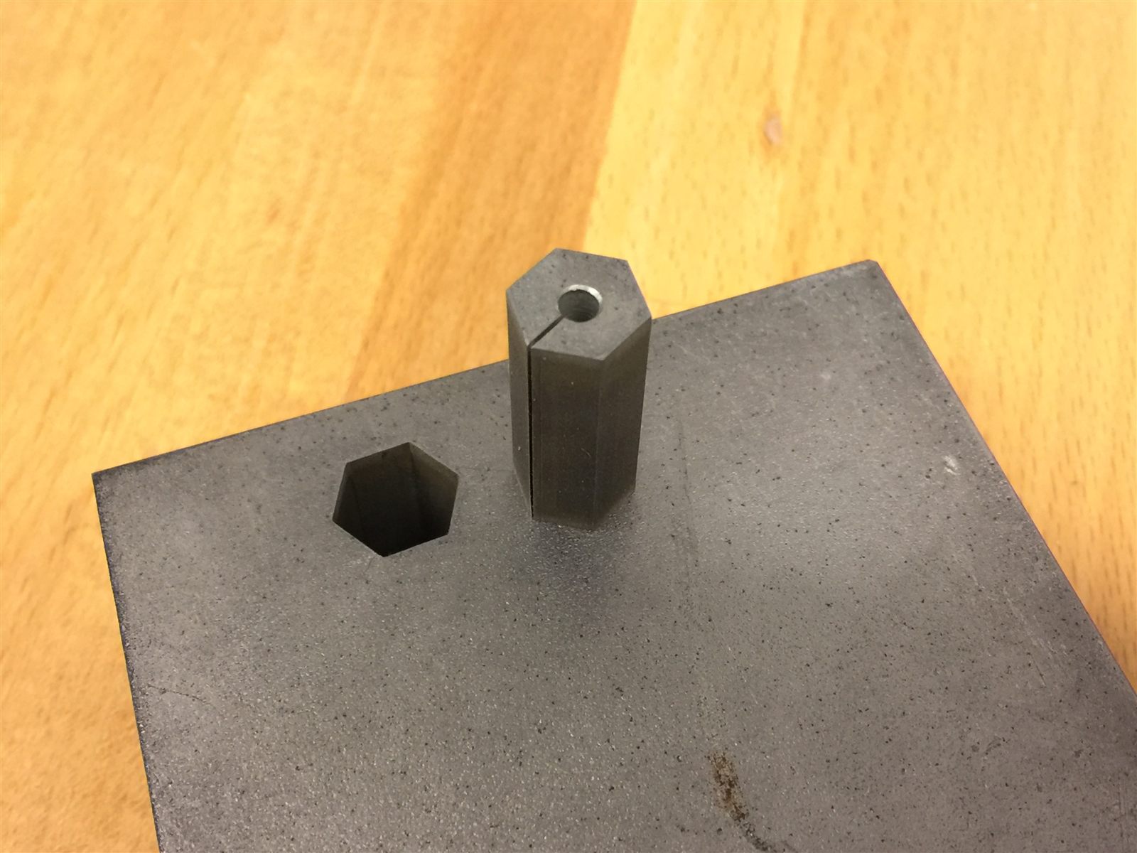 Hexagonal punch standing beside its hole